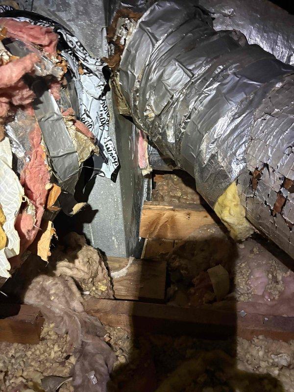 Performed second opinion evaluation on 2.5 ton residential cooling system installed in 2021 serving 1200-1500 square foot home with enclosed garage. System reported not cooling adequately with thermostat unable to maintain temperature below 80 degrees. Inspected attic ductwork and found 10-inch supply duct disconnected from plenum, confirmed by photographic documentation showing separated flexible ductwork with displaced insulation in attic space. Assessed outdoor condensing unit condition and verified concerns regarding dirty coil requiring cleaning. Evaluated refrigerant charge levels and confirmed low refrigerant condition requiring leak detection and repair. Reviewed system capacity relative to conditioned space and determined 2.5 ton unit appropriately sized for square footage. Documented ductwork installation quality including loose-fill insulation and flexible duct routing through attic crawl space. Provided property manager with findings to compare against previous technician's
