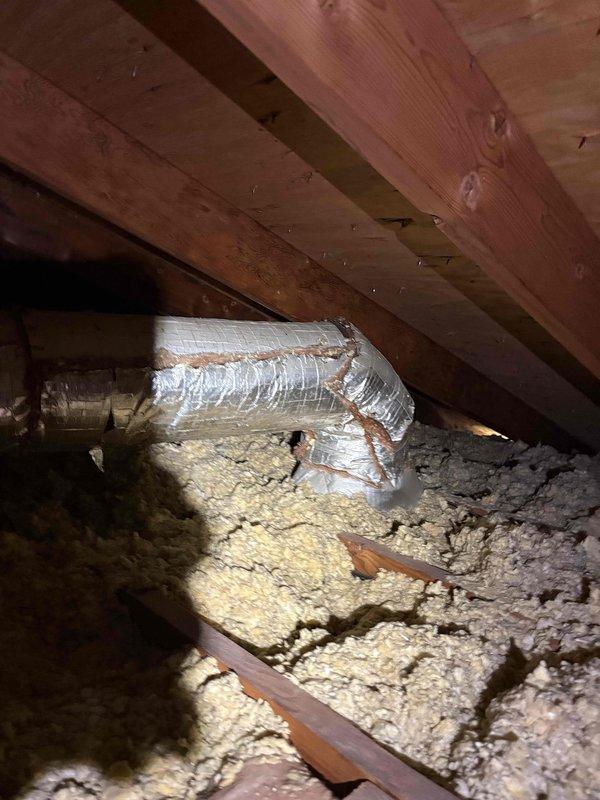 Performed second opinion evaluation on 2.5 ton residential cooling system installed in 2021 serving 1200-1500 square foot home with enclosed garage. System reported not cooling adequately with thermostat unable to maintain temperature below 80 degrees. Inspected attic ductwork and found 10-inch supply duct disconnected from plenum, confirmed by photographic documentation showing separated flexible ductwork with displaced insulation in attic space. Assessed outdoor condensing unit condition and verified concerns regarding dirty coil requiring cleaning. Evaluated refrigerant charge levels and confirmed low refrigerant condition requiring leak detection and repair. Reviewed system capacity relative to conditioned space and determined 2.5 ton unit appropriately sized for square footage. Documented ductwork installation quality including loose-fill insulation and flexible duct routing through attic crawl space. Provided property manager with findings to compare against previous technician's