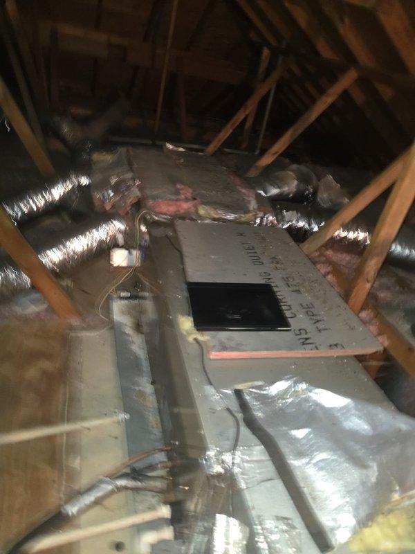 Conducted attic inspection and photographed existing HVAC air handler installation. Documented central air handler unit mounted on platform with associated flexible ductwork distribution system. Observed condensate pump assembly, electrical connections, and insulated duct runs throughout attic space. Assessed current equipment configuration and accessibility for future service requirements.