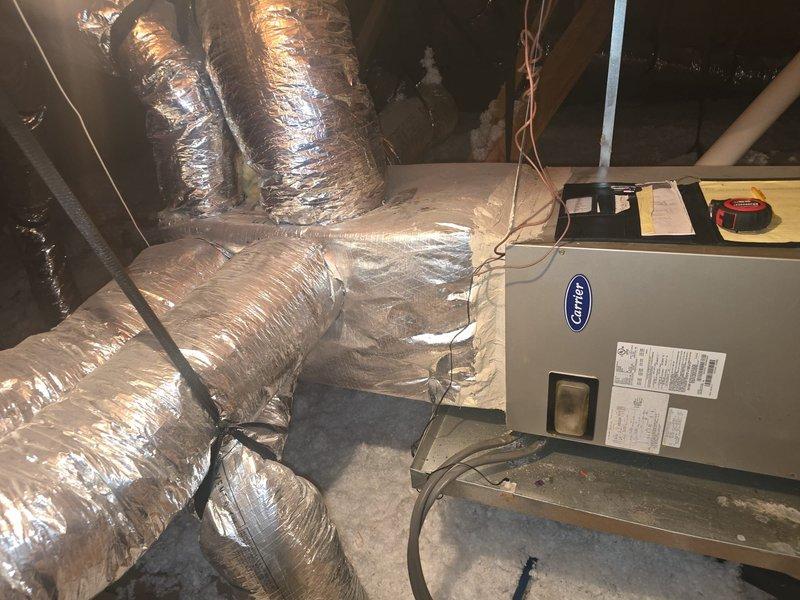 Responded to service call for Carrier air handler unit that stopped functioning following multiple power outages. Conducted diagnostic inspection of attic-mounted HVAC system and confirmed control board failure as suspected cause of system malfunction. Documented equipment condition with photos showing air handler installation, ductwork connections, refrigerant lines, and condensate drain configuration for estimate preparation and repair recommendations.