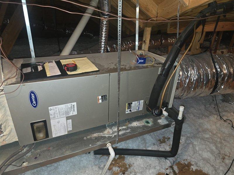 Responded to service call for Carrier air handler unit that stopped functioning following multiple power outages. Conducted diagnostic inspection of attic-mounted HVAC system and confirmed control board failure as suspected cause of system malfunction. Documented equipment condition with photos showing air handler installation, ductwork connections, refrigerant lines, and condensate drain configuration for estimate preparation and repair recommendations.