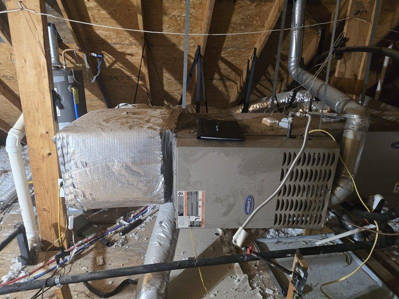 Conducted site assessment of attic HVAC installation to provide estimate per customer's emailed quote request. Documented existing Carrier equipment, air handler unit, insulated ductwork system including silver flexible and rigid ducts, refrigerant lines, electrical connections, and drain pan configuration. Photographed complete installation layout showing equipment positioning between roof trusses, connection points, and overall system condition for accurate proposal development.