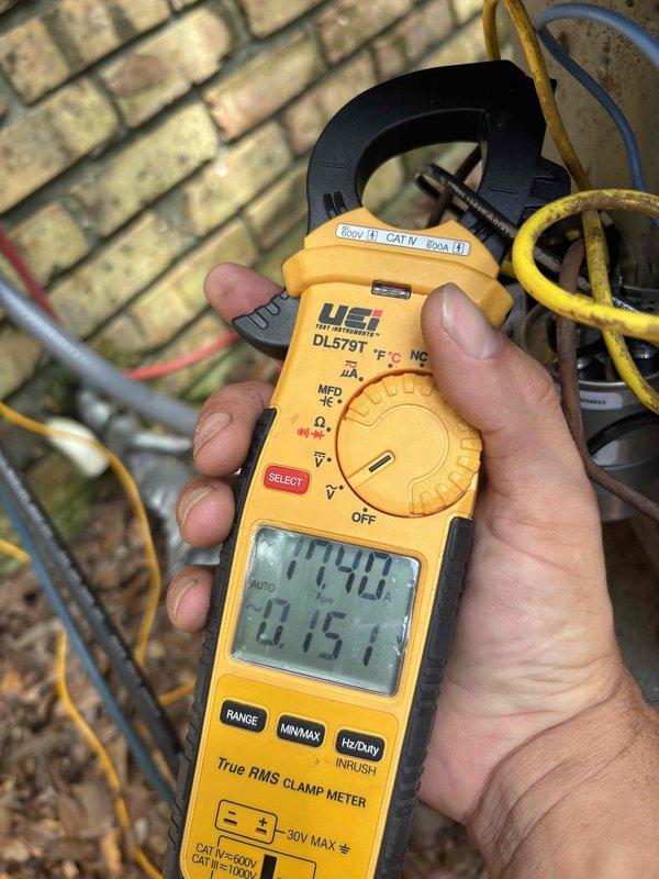 Responded to no cooling complaint on 2013 R22 system with condenser and coil replaced in same year. Performed diagnostic evaluation and electrical measurements using clamp meter on outdoor unit. System assessed for refrigerant charge levels due to suspected low freon condition. Unit specifications confirmed as R22 refrigerant system with significant dust accumulation on cabinet surfaces noted during inspection.