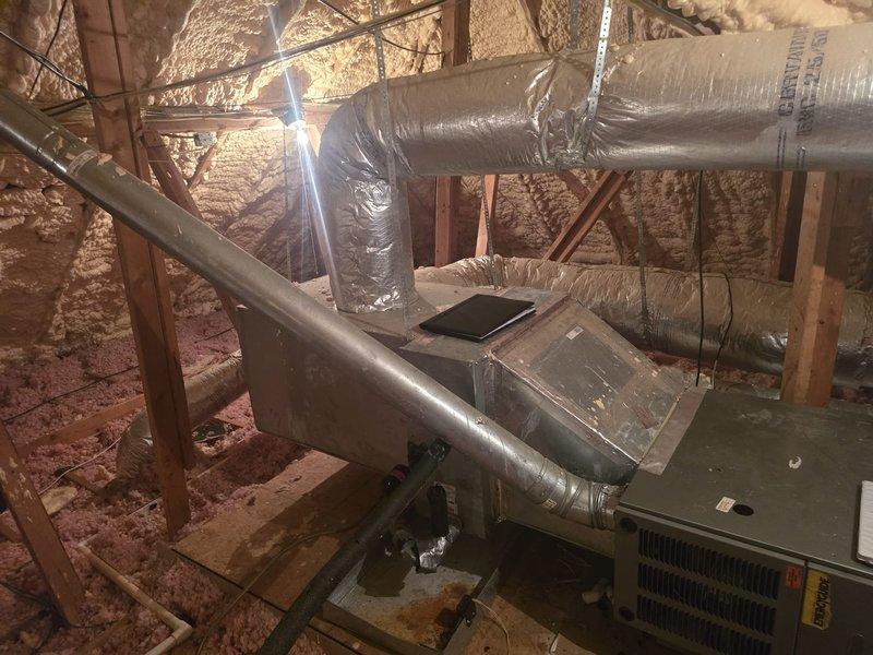 Conducted comprehensive estimate for complete HVAC system replacement on residential property. Inspected existing Bryant condenser unit located on exterior gravel pad against brick wall with proper electrical disconnects and service boxes in place. Evaluated attic-mounted air handler and ductwork system, noting current configuration with flexible duct runs and insulation. Customer reported suspected evaporator coil leak based on third-party assessment. Documented existing equipment conditions through photographic evidence and provided replacement system options to address reported refrigerant leak issue.