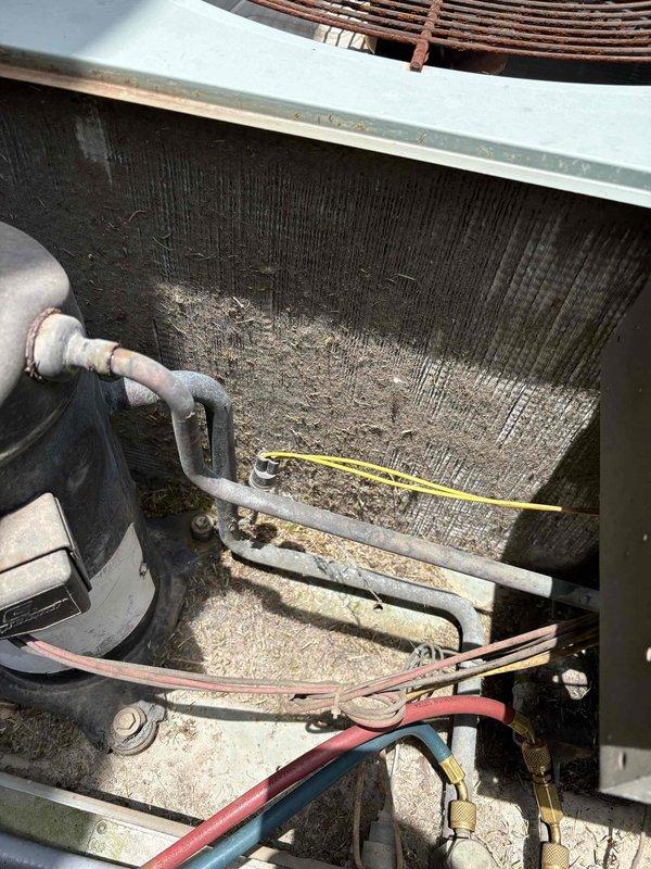 Responded to no-cooling complaint on one of two residential HVAC systems serving kitchen, living room, and front bedroom areas. Upon arrival, unit was turned off by homeowner due to warm air discharge. Performed diagnostic inspection revealing severely clogged evaporator coil with heavy accumulation of dirt, dust, and debris throughout coil fins, particularly concentrated in central areas. Documented condition of 2005-era equipment showing significant lack of recent maintenance. Inspected attic-mounted air handler unit and associated ductwork system. Presented membership program options to customer for ongoing maintenance needs.