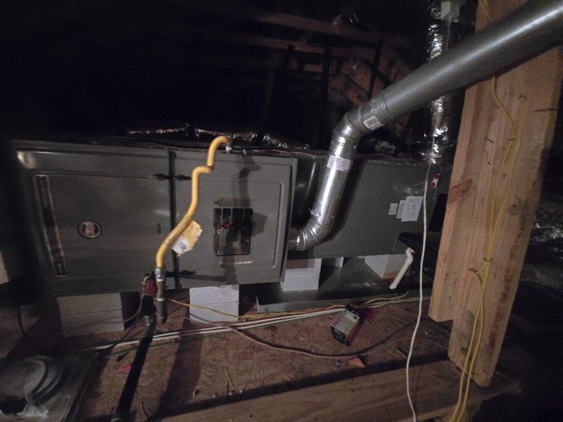 Completed coil replacement and annual cooling maintenance on residential HVAC system located in attic space. Removed and replaced evaporator coil on gray metal air handler unit positioned on support blocks. Verified proper connection of gas line to unit and inspected all ductwork connections including metallic supply duct with copper elbow joint. Checked electrical connections and wiring throughout system. Performed comprehensive cooling system maintenance including inspection of all mechanical components, ductwork integrity, and insulation wrapping. Confirmed proper airflow through supply ducts and verified system operation. All work completed same day per purchase order specifications with materials picked up from supply house. System tested and operating within manufacturer specifications upon completion.