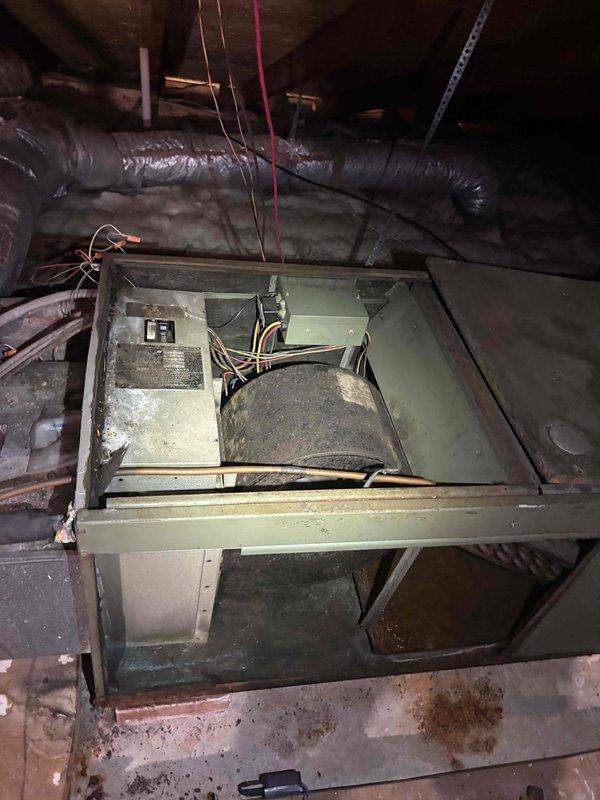 Responded to no-cooling call with reported frozen refrigerant line on aging attic-mounted air handler unit. Upon inspection, found extremely dirty blower wheel with heavy dust and debris accumulation restricting airflow, along with heavily soiled evaporator coil visible through access panel. Unit exhibited significant age-related wear with rust staining on interior metal surfaces and dusty internal components throughout cabinet. Documented existing conditions with photos showing compromised blower assembly, deteriorated coil section, and overall poor maintenance history. System requires thorough cleaning of blower wheel and evaporator coil to restore proper airflow and prevent future freeze-ups, along with comprehensive evaluation of refrigerant charge once airflow is corrected.