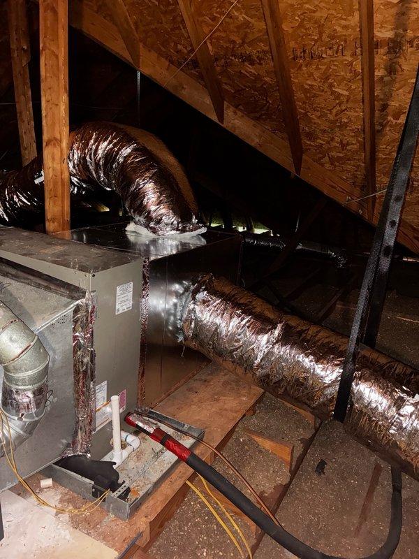 Installed four 10-inch flexible ducts and one 12-inch flexible duct in attic space, connecting to existing HVAC air handler unit. Addressed critical deficiency by fabricating and installing sheet metal piece to seal gap exceeding 1 inch wide where evaporator coil connects to plenum, preventing hot air infiltration that was compromising system cooling efficiency. Secured sheet metal with screws and properly sealed all connections to eliminate air leakage. Removed plastic material obstructing furnace vent pipe and trimmed combustible materials to establish required 1-inch minimum clearance from gas furnace flue pipe per code requirements. Verified refrigerant charge and system pressures, confirming proper levels. Tested complete HVAC system operation to ensure adequate cooling performance and proper functionality following repairs.