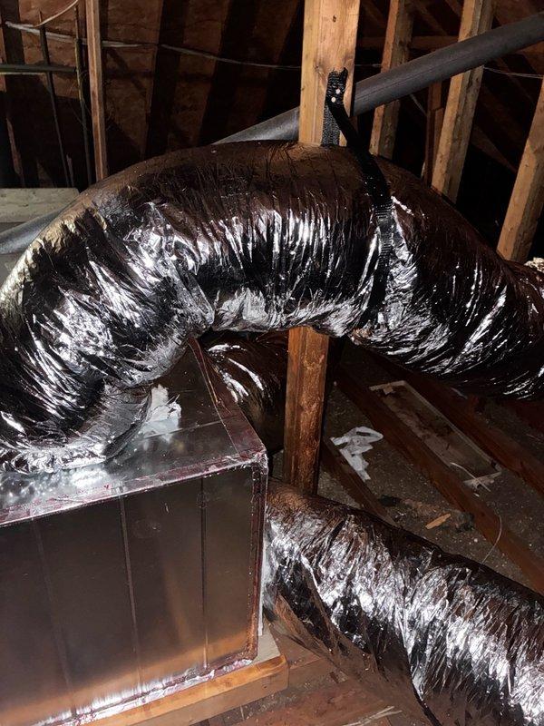 Installed four 10-inch flexible ducts and one 12-inch flexible duct in attic space, connecting to existing HVAC air handler unit. Addressed critical deficiency by fabricating and installing sheet metal piece to seal gap exceeding 1 inch wide where evaporator coil connects to plenum, preventing hot air infiltration that was compromising system cooling efficiency. Secured sheet metal with screws and properly sealed all connections to eliminate air leakage. Removed plastic material obstructing furnace vent pipe and trimmed combustible materials to establish required 1-inch minimum clearance from gas furnace flue pipe per code requirements. Verified refrigerant charge and system pressures, confirming proper levels. Tested complete HVAC system operation to ensure adequate cooling performance and proper functionality following repairs.