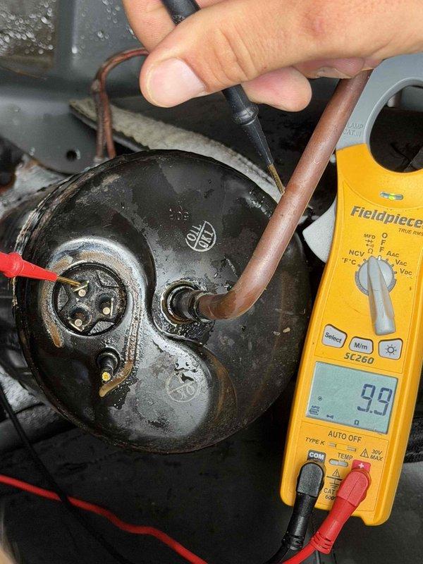 Responded to no cooling complaint on downstairs HVAC system in home with two approximately 20-year-old units. Upon arrival, performed electrical diagnostics on the downstairs outdoor unit compressor. Using digital multimeter, tested compressor motor windings and electrical connections to determine operational status. Measurements indicated compressor failure, preventing the downstairs system from operating. Upstairs system confirmed to be running continuously in attempt to compensate for non-functional downstairs unit, causing inadequate cooling throughout home. Documented findings with diagnostic photos showing compressor testing procedures and meter readings. Advised that downstairs system requires compressor replacement or full outdoor unit replacement due to age of equipment. Recommended evaluation of both systems given their advanced age and potential for additional component failures.