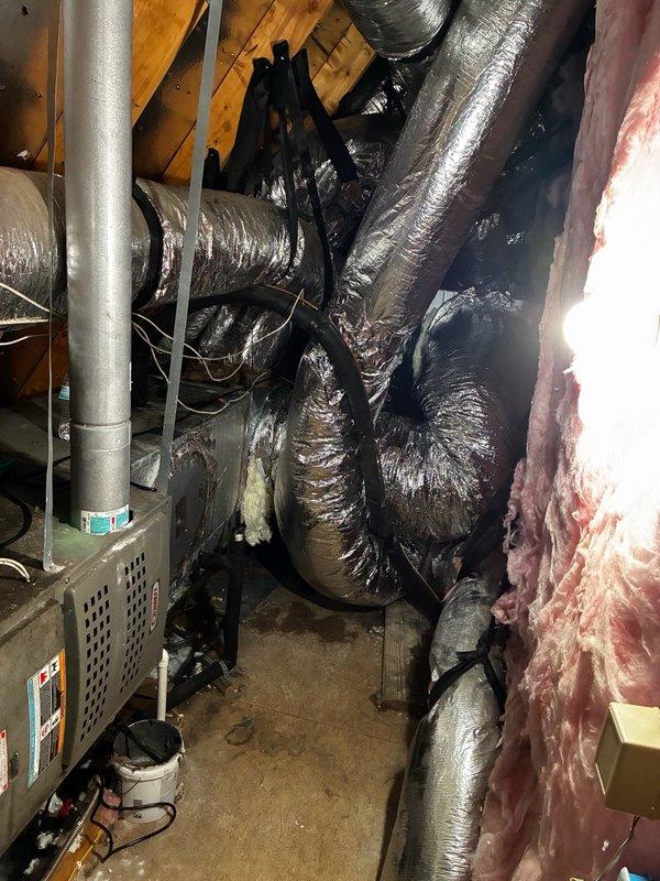 Completed medium-complexity HVAC installation involving ductwork modifications and UV light system integration in attic space. Installed flexible ductwork with reflective insulation material, routing multiple supply runs throughout the confined crawl space area while maintaining proper airflow paths and securing all sections with appropriate mounting brackets and straps. Connected ductwork to existing air handler unit, ensuring proper sealing and structural support to prevent sagging or compression. Integrated UV light system into the HVAC configuration per specifications. Coordinated delivery of 10x8 supply grills for final installation phase. All ductwork was properly insulated and secured to building framing members using black plastic strapping to maintain system integrity. Work completed in challenging attic environment with limited clearance, requiring careful navigation around existing pink fiberglass insulation and wooden structural elements. System tested for proper air distri
