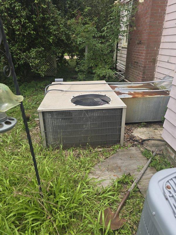 Completed installation of 3-ton gas heating and air conditioning system at residential property. Three-person crew removed existing HVAC equipment and installed new outdoor condenser unit on concrete pad adjacent to home exterior with proper clearances maintained. Unit positioned on level surface next to residential structure with brick chimney, ensuring adequate airflow and accessibility for future service. New system started up successfully, all operational parameters verified within manufacturer specifications, and installation documentation completed per standard procedures.
