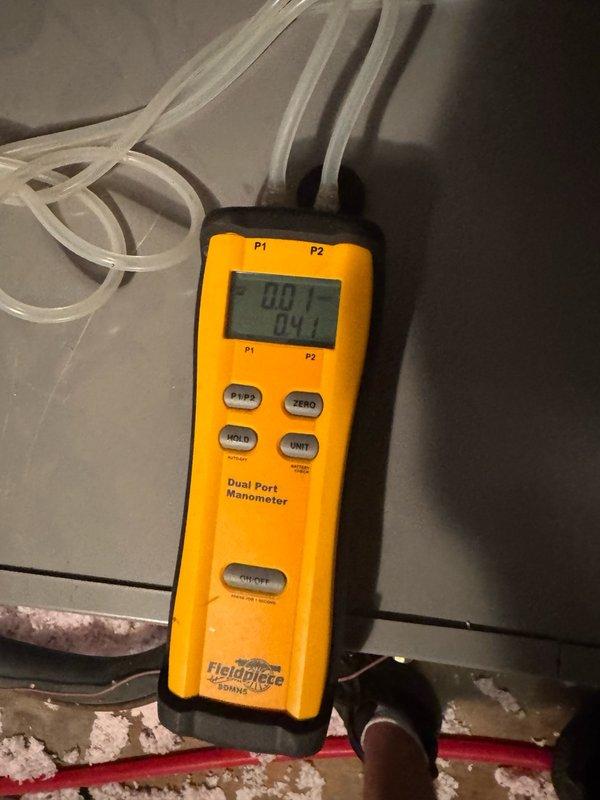 Responded to no cooling complaint on residential air conditioning system. Upon inspection, found outdoor condenser unit with heavily soiled coils showing significant dirt, dust, and debris accumulation affecting heat transfer efficiency. Measured system pressures using dual port manometer, recording readings of 80.1 and 84.1 PSI at indoor unit. Condenser coils displayed brown discoloration with dark vertical streaking throughout, indicating extended period without maintenance. Unit operational but performance compromised by restricted airflow through contaminated coil surfaces. Recommended thorough coil cleaning and system maintenance to restore proper cooling capacity and efficiency.