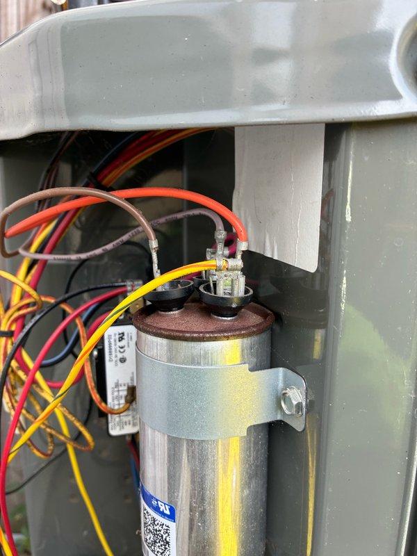 # HVAC Condenser Fan Motor Failure

Responded to no cooling complaint with indoor temperature at 82°F. Thermostat calling for cooling but outdoor unit fan not operating. Performed diagnostic testing on single-zone electric air conditioning system. Used clamp meter to verify amperage draw on condenser fan motor, which measured 5.08 amps. Inspected fan motor assembly, capacitor, and associated electrical connections. Fan motor determined to be inoperative despite proper capacitor and electrical supply. Photographed diagnostic readings and capacitor wiring configuration showing multiple wire connections with terminal blocks. Capacitor appeared serviceable with proper connections intact. Issue isolated to failed condenser fan motor preventing heat rejection from outdoor unit.