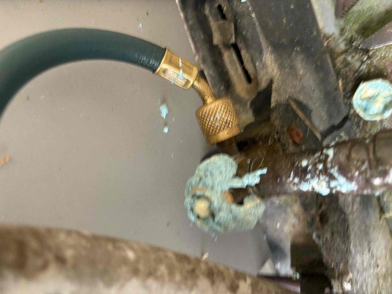Responded to after-hours dispatch for a 5-year-old HVAC system reported to be running continuously without reaching setpoint temperature. Upon arrival, performed visual inspection of outdoor unit and refrigerant line connections. Documented significant corrosion and oxidation present on copper tubing, service valves, and refrigerant line fittings, with visible turquoise-green patina indicating prolonged exposure to outdoor elements and potential refrigerant leak points. Service port connections showed weathering and deterioration consistent with age and environmental exposure. Captured photographic documentation of corroded brass fittings, deteriorated refrigerant lines, and heavily oxidized components for further evaluation and repair recommendations.