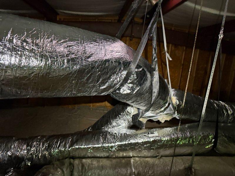 Completed HVAC installation including cutting and installing flexible ductwork for multiple supply runs in attic space with proper support strapping and fasteners. Installed remote return air vent with grille cover, ensuring proper airflow integration with existing system.