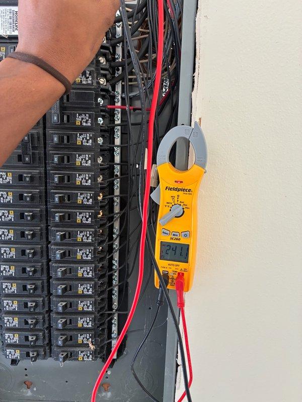Completed warranty compressor replacement on basic Carrier system with soft start installation. Verified proper electrical connections at breaker panel with current draw reading of 24.1 amps, then confirmed compressor operation with final amperage of 73.3 amps at the unit, indicating successful installation and normal operating parameters.