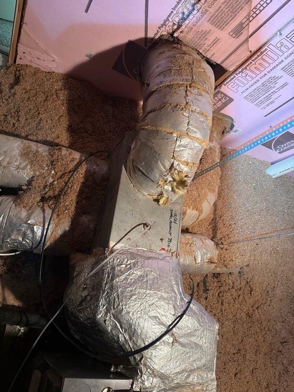 Responded to callback for recurring condensate pan filling issue on same unit from recent service visit. Upon arrival, performed diagnostic pressure testing using digital manometer, which revealed readings of 0.89 and -1.04, indicating potential airflow restriction or drainage obstruction. Inspection of attic-installed HVAC system revealed heavily soiled flexible ductwork and components with significant dust and debris accumulation throughout the system. Documented existing conditions with photos showing substantial particulate buildup on main supply duct, rigid duct sections, and surrounding components. Assessment indicates compromised system cleanliness may be contributing to condensate drainage problems. Customer had temporarily removed water from pan overnight prior to service call.