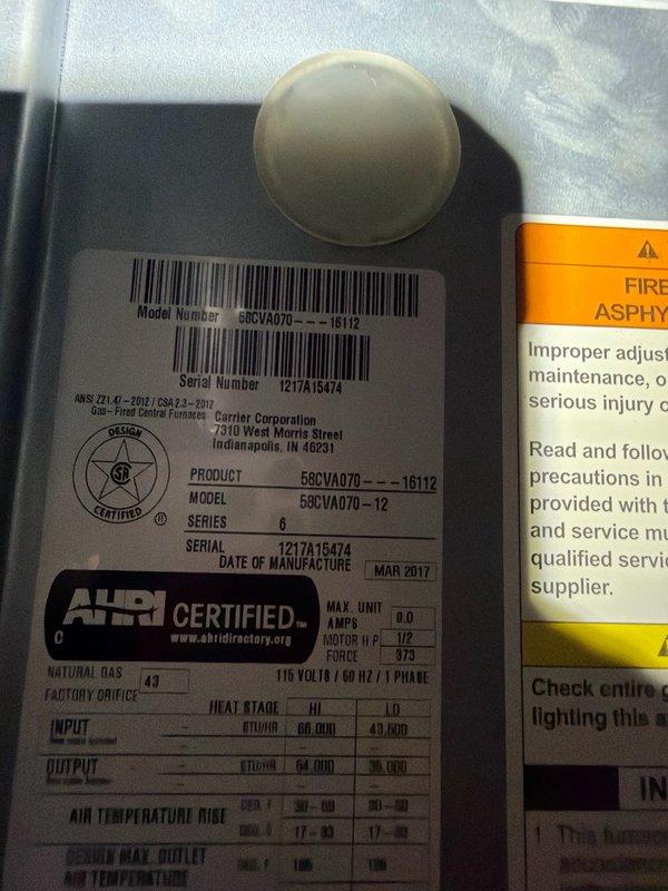 Responded to callback for outdoor HVAC unit experiencing freezing issues following recent compressor replacement. Inspected Carrier system (Model 58CVA070, Serial 1217A15474, manufactured March 2017) and refrigerant line configuration running from outdoor unit to indoor components. Documented current installation condition including refrigerant lines with insulation and overall system setup to assess potential causes of freeze-up condition such as refrigerant charge levels, airflow restrictions, or metering device issues related to recent compressor service.