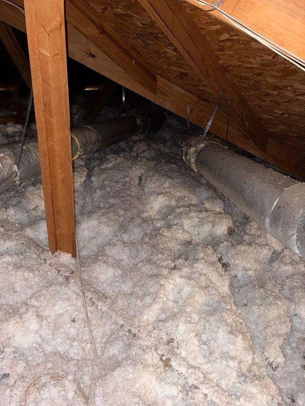 Performed no-charge second opinion inspection of attic ductwork after another contractor identified a disconnected trunk line. Confirmed 10-inch flexible trunk line detached from 12x6 supply drop, actively discharging conditioned air into attic space instead of living area. Documented existing conditions with photographs showing loose ductwork coiled in attic with blown insulation and standard HVAC infrastructure. Assessed scope of repair required to properly reattach and secure disconnected duct section to restore proper airflow to intended zone.