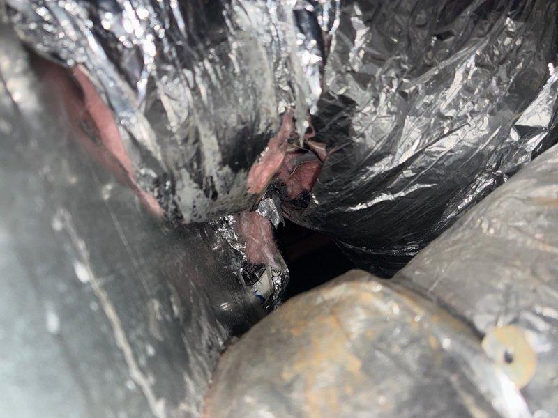 Performed second opinion diagnostic on residential HVAC system experiencing inadequate cooling, unable to maintain temperature below 78 degrees following previous service visit. Conducted comprehensive system evaluation including visual inspection of indoor and outdoor equipment. Documented attic ductwork conditions, noting damaged insulation at duct connections and deteriorated vapor barrier material exposing gaps in the system envelope. Photographed flex duct installations showing compression, wear patterns, and compromised insulation integrity that may contribute to cooling efficiency losses. Assessed overall system performance and provided findings to address cooling deficiency concerns.