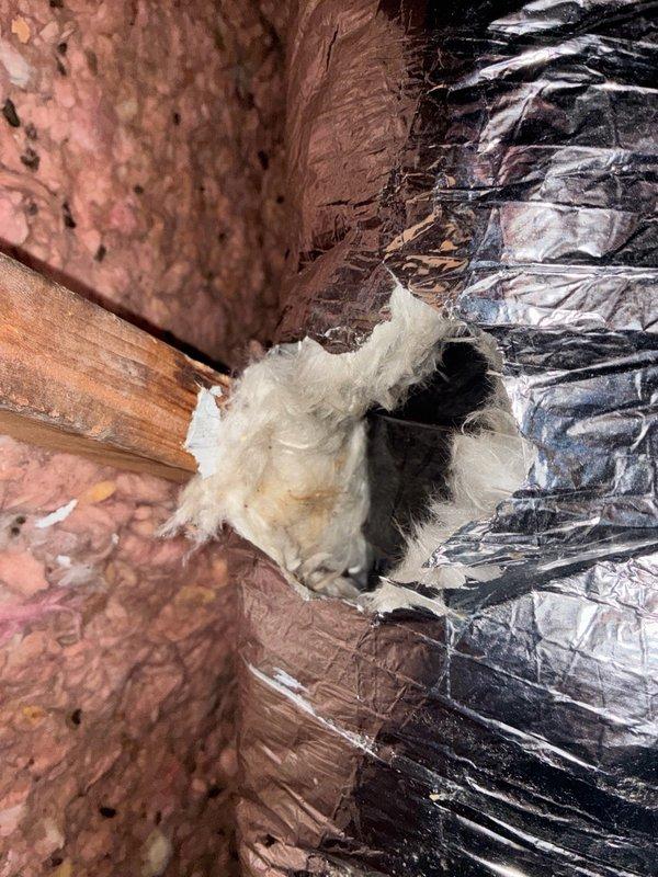 Performed second opinion diagnostic on residential HVAC system experiencing inadequate cooling, unable to maintain temperature below 78 degrees following previous service visit. Conducted comprehensive system evaluation including visual inspection of indoor and outdoor equipment. Documented attic ductwork conditions, noting damaged insulation at duct connections and deteriorated vapor barrier material exposing gaps in the system envelope. Photographed flex duct installations showing compression, wear patterns, and compromised insulation integrity that may contribute to cooling efficiency losses. Assessed overall system performance and provided findings to address cooling deficiency concerns.