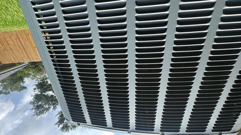 Completed installation of drain pan for outdoor air conditioning condenser unit. Applied sealant to ensure proper water containment and prevent potential water damage to surrounding areas. Unit tested and verified operational with new drain pan properly positioned beneath refrigerant lines.