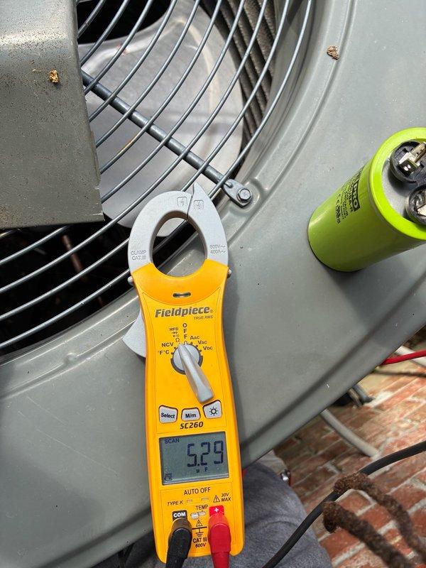 Responded to no cooling call where system was running but blowing warm air. Upon arrival, performed diagnostic testing on outdoor condensing unit using clamp meter. Measured compressor amperage at 52.9 amps and fan motor drawing 35.52 amps. Verified condenser fan motor operation and inspected capacitor condition. No refrigerant line icing observed at time of inspection. System operational with airflow confirmed through outdoor unit fan assembly.