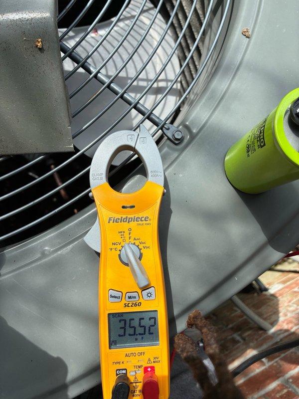 Responded to no cooling call where system was running but blowing warm air. Upon arrival, performed diagnostic testing on outdoor condensing unit using clamp meter. Measured compressor amperage at 52.9 amps and fan motor drawing 35.52 amps. Verified condenser fan motor operation and inspected capacitor condition. No refrigerant line icing observed at time of inspection. System operational with airflow confirmed through outdoor unit fan assembly.