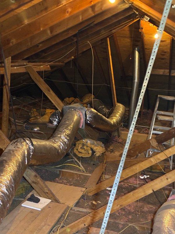 Responded to cooling concern and investigated moisture issue in attic-mounted HVAC system. Found drain pan dry but surrounding insulation saturated with water. Inspected air handler unit and observed significant mold/dust accumulation on interior panels and evidence of moisture infiltration with staining patterns on metal components. Documented conditions with photographs showing compromised insulation between joists and deteriorated ductwork components. Unit currently operational and providing cooling. Identified potential condensation leak from air handler or ductwork connections as probable source of insulation saturation, though drain pan itself not retaining standing water. Recommended further investigation to determine exact leak source and address biological growth on internal components.