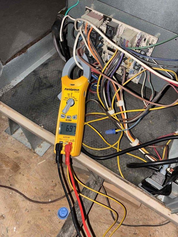 Completed large-scale repair addressing water intrusion issue caused by improper condensate drain line installation with insufficient pitch running beneath the HVAC unit. Performed electrical diagnostics using digital multimeter and clamp meter to verify system operation, measuring voltage and amperage at control panel and outdoor unit connections. Rerouted and re-pitched condensate drain line to establish proper gravity flow and prevent water backup into equipment cabinet, though complete resolution pending full drying period to assess effectiveness of drainage modifications.