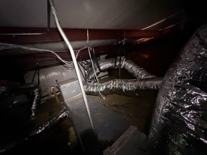 Completed large-scale ductwork installation for commercial office space encompassing approximately 2,300 square feet with multiple offices, break room, lobby, and bathroom facilities. Routed flexible aluminum ductwork through attic crawl space, coordinating runs with existing electrical wiring and PVC plumbing to ensure proper airflow distribution to all nine designated zones per floor plan specifications. Installation included navigating confined spaces between structural beams and making necessary bends and connections to service all rooms while maintaining code-compliant clearances from other building systems.