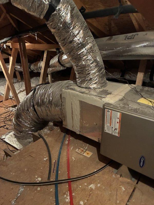 Responded to service call for HVAC system blowing warm air. Due to customer mobility limitations preventing attic access, advised system be turned off with fan left in circulation mode until technician arrival. Accessed attic space and documented existing air handler installation and flexible ductwork configuration. System reported to be out of warranty with unknown installation date.