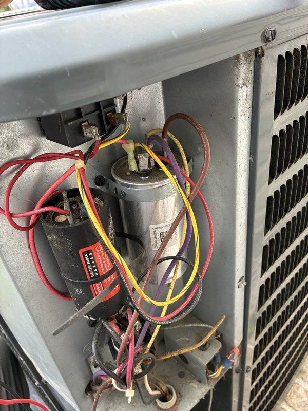 Responded to no cooling complaint with outdoor unit running but not producing cold air, particularly affecting master bathroom. Performed diagnostic testing on outdoor condensing unit using clamp meter to measure electrical values and inspected capacitor functionality. Measured amperage reading of 76.0 amps and evaluated capacitor (model PRCFD455A) connections and performance. Examined condenser coil condition and internal electrical components including wiring connections to capacitor and contactor assembly.
