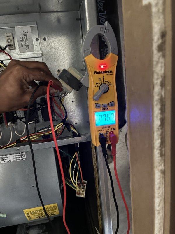 # VIJ - AC Tune-Up Completed

Performed comprehensive annual cooling maintenance on residential HVAC system. Conducted thorough electrical diagnostics using clamp meter, measuring amperage draw on indoor air handler unit at 27.57 amps and outdoor condenser unit voltage at 1169 (likely line voltage verification). Inspected all electrical connections, wiring harnesses, and control boards within air handler cabinet. Verified proper operation of compressor, condenser coils, and all system components. All measurements within manufacturer specifications. System operating efficiently with no issues identified during complete tune-up service.