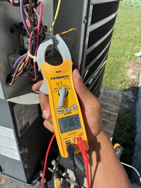 # VIJ - AC Tune-Up Completed

Performed comprehensive annual cooling maintenance on residential HVAC system. Conducted thorough electrical diagnostics using clamp meter, measuring amperage draw on indoor air handler unit at 27.57 amps and outdoor condenser unit voltage at 1169 (likely line voltage verification). Inspected all electrical connections, wiring harnesses, and control boards within air handler cabinet. Verified proper operation of compressor, condenser coils, and all system components. All measurements within manufacturer specifications. System operating efficiently with no issues identified during complete tune-up service.