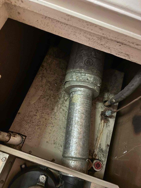 Responded to service call for HVAC system evaluation. Customer reported possible refrigerant leak in attic air handler from previous technician visit approximately one year ago. Performed visual inspection of aging air handler unit and blower motor assembly. Documented existing equipment condition with photos showing significant dust accumulation, age-related deterioration, and staining on interior surfaces. Assessed blower motor, copper refrigerant lines, and overall cabinet condition. Provided customer's authorized decision-maker with repair versus replacement options for the air handler unit, noting the condenser is relatively new at only a few years old while the air handler shows considerable age and wear.