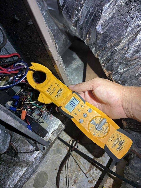 Completed fall tune-up and preventative maintenance on single heating system for member. Performed comprehensive system diagnostics including electrical testing with clamp meter, verified proper amperage draw, and inspected all electrical connections and components within the unit. During inspection, identified deteriorated fiberglass insulation in attic space around ductwork junction where flexible duct connects to main supply plenum, with insulation material hanging loose and compromising thermal efficiency. System operational and heating properly upon completion of tune-up service.