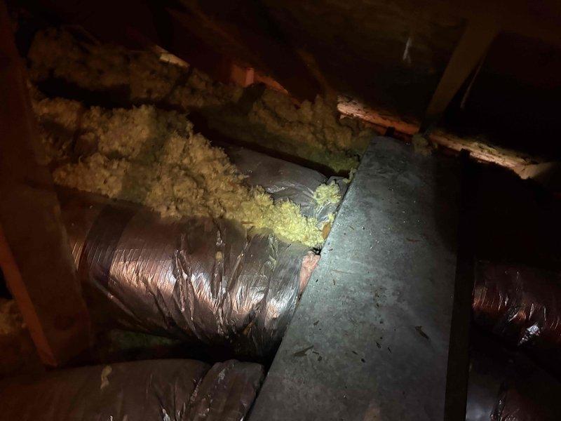 Completed fall tune-up and preventative maintenance on single heating system for member. Performed comprehensive system diagnostics including electrical testing with clamp meter, verified proper amperage draw, and inspected all electrical connections and components within the unit. During inspection, identified deteriorated fiberglass insulation in attic space around ductwork junction where flexible duct connects to main supply plenum, with insulation material hanging loose and compromising thermal efficiency. System operational and heating properly upon completion of tune-up service.