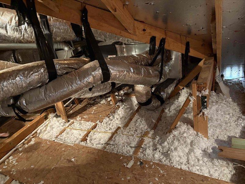 Responded to callback for excessive condensation on attic ductwork installed in July. Upon inspection, found flexible ductwork in attic space with visible sweating on exterior surfaces. Documented conditions with photos showing multiple runs of insulated flex duct suspended from ceiling joists, some sections in close proximity to each other. Verified plenum, transition, and evaporator coil installation from previous service. No water damage observed on ceiling below at time of inspection. Assessed ductwork insulation integrity and support system throughout accessible attic areas.