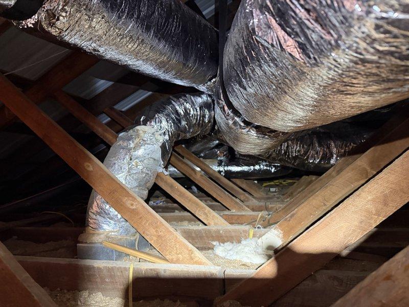 Completed installation of 4-ton side discharge HVAC system with full ductwork over a two-day period. Navigated attic space through side access, exercising caution around overhead power lines as noted in site conditions. Routed flexible insulated ductwork through existing attic structural framework, connecting multiple trunk and branch lines to ensure proper air distribution throughout the residence. Installation included cutting access points in attic flooring as needed and securing all ductwork to wooden framing members per code requirements. All ductwork properly insulated and sealed at connection points to maximize system efficiency and minimize air leakage.