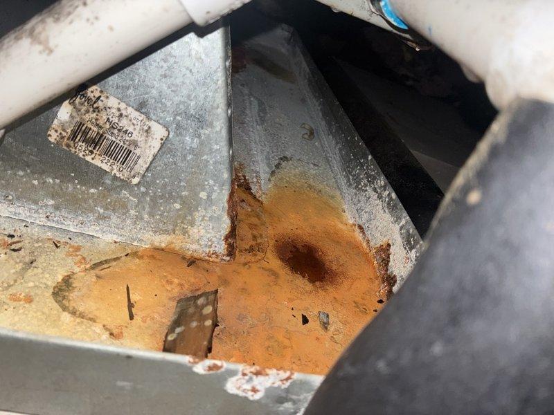 Completed comprehensive heater tune-up and inspection on single-system HVAC unit. Performed thorough cleaning of blower motor assembly, verified 1/6 HP Fasco motor operating within specifications at 208-230V, 3000 RPM. Inspected condensate drain pan and documented significant rust staining and sediment accumulation indicating prolonged water exposure and oxidation. Checked all electrical connections, PVC drainage lines, and verified proper airflow through blower housing. System operational upon completion of service.