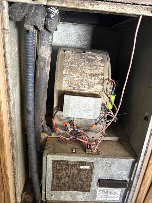 Completed fall maintenance tune-up on single heating system in residential utility space. Performed comprehensive inspection of furnace unit, tested electrical components using clamp meter with voltage readings within normal operating parameters at 23V, verified all control wiring connections secure, and confirmed proper system operation. Unit showed age-appropriate wear with dust accumulation cleaned during service visit.