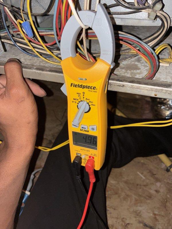 Performed a heater tune-up including cleaning and inspection of the gas furnace with the access panel removed. Verified electrical operation using a clamp meter, checking amperage on the supply wiring and testing voltage at the gas valve, and inspected the inducer motor, pressure switch, flue assembly, and wiring connections for proper condition and function.