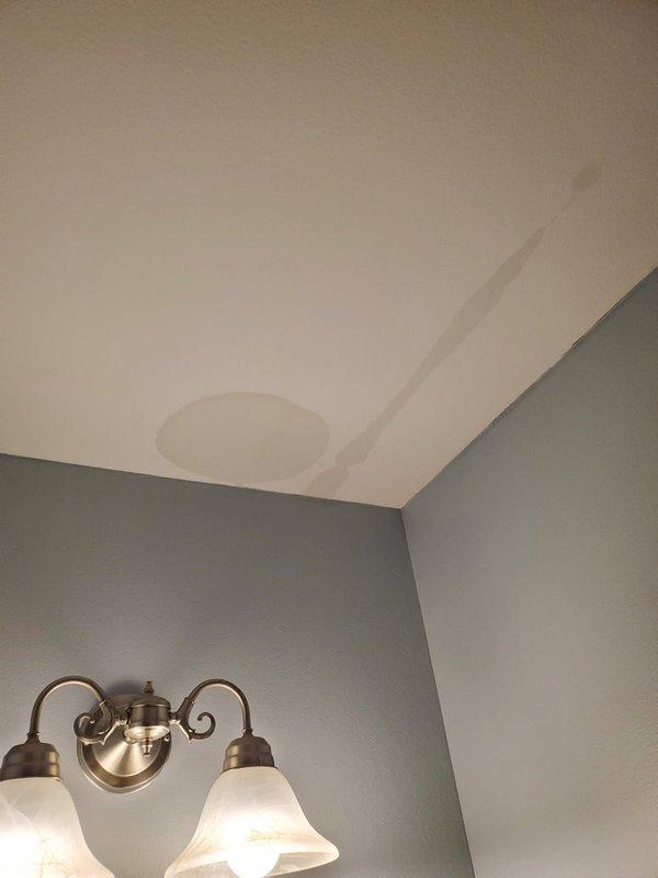 Performed annual heating maintenance and responded to a reported condensate drain line separation that was causing water intrusion into the bathroom. Inspected the primary float switch and condensate drain system, then re-secured the disconnected drain line with black duct strap to restore proper drainage. Documented water staining on the ceiling below the unit from the leak.