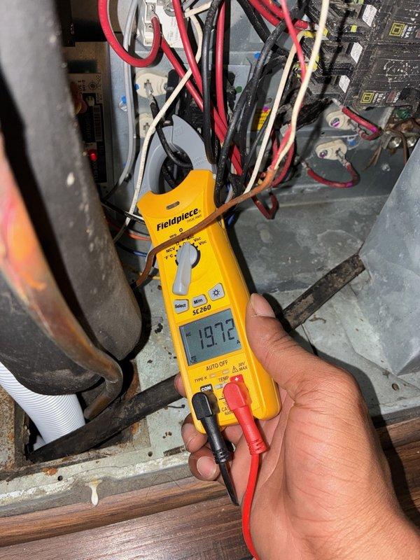 Responded to a no-heat call on a customer-installed Honeywell thermostat that operated cooling but offered no heating option. Inspected the air handler's evaporator coil and electrical compartment, and measured amperage with a clamp meter to evaluate system operation. The coil showed moderate dust accumulation with no frost or physical damage, and the thermostat's heating configuration and wiring should be verified against the equipment type.
