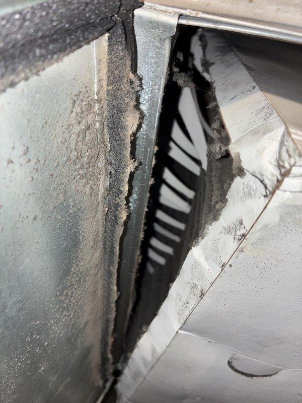 Performed AC tune-up on electric split system in response to elevated utility bills and uneven cooling. Inspected the attic air handler and found the return plenum and insulated duct surfaces heavily coated with dust and lint, and the pleated filter loaded with soot and debris with worn frame edges, restricting airflow. Removed the dirty filter, cleaned accumulated debris from the plenum and housing, and verified the system for proper airflow to help improve efficiency and temperature balance to the warmer side of the home.