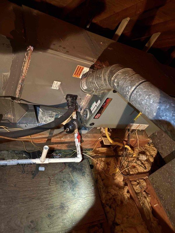 Performed full tune-up inspections on two attic-mounted HVAC systems (a gas furnace/air handler unit and its associated components) as part of a pre-sale evaluation, checking the equipment, gas supply line, condensate drain assembly with shutoff valve, and electrical connections. Found a torn seam in the foil-faced flexible supply duct with insulation bulging through the split, along with compressed and uneven attic insulation, both of which are recommended for repair to restore duct integrity and efficiency.