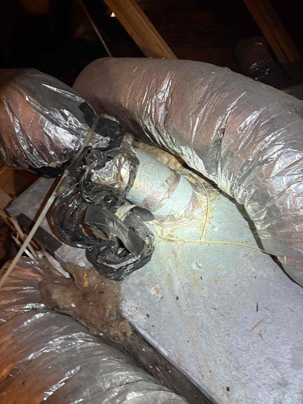 Performed a diagnostic inspection and tune-up on a 15-year-old R-22 split system air handler located in the attic after reported water intrusion from a failed attic pipe. Inspected the plenum, flexible duct connections, and control compartment, noting corrosion and rust streaking on the casing, deteriorated and disordered duct taping and strapping, displaced insulation, debris accumulation, and tangled control wiring with possible moisture damage. Evaluated the unit's condition to support a second-opinion repair assessment and documented findings with photos for a detailed estimate of the repairs needed to restore system operation.