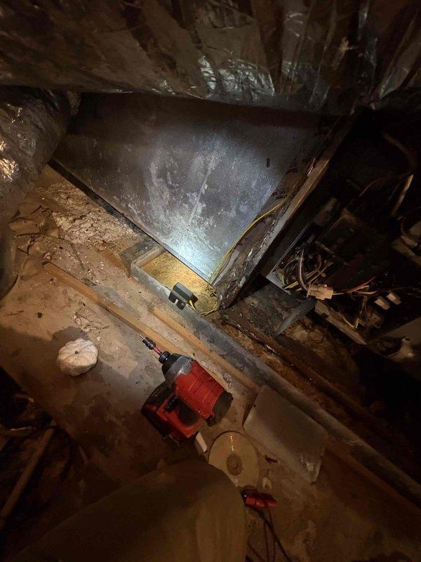 Performed a diagnostic inspection and tune-up on a 15-year-old R-22 split system air handler located in the attic after reported water intrusion from a failed attic pipe. Inspected the plenum, flexible duct connections, and control compartment, noting corrosion and rust streaking on the casing, deteriorated and disordered duct taping and strapping, displaced insulation, debris accumulation, and tangled control wiring with possible moisture damage. Evaluated the unit's condition to support a second-opinion repair assessment and documented findings with photos for a detailed estimate of the repairs needed to restore system operation.